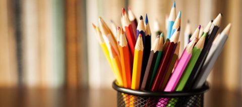 Wire desk tidy full of coloured pencils